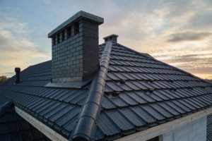 black metal roof on home with brick chimney
