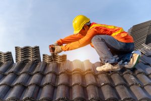 A roof worker completing an inspection on a shingle roof